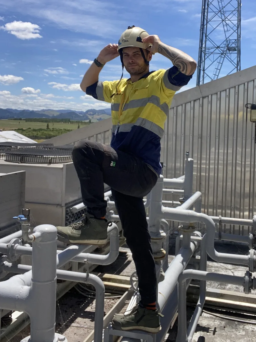 Mark Law, refrigeration technician and owner of Prograde Refrigeration, on a rooftop plant deck alongside chilled water pipework